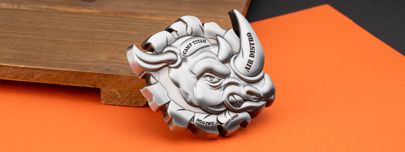 Antique silver coin sculpted as a charging rhino head bursting through the coin, on dark wood and orange paper