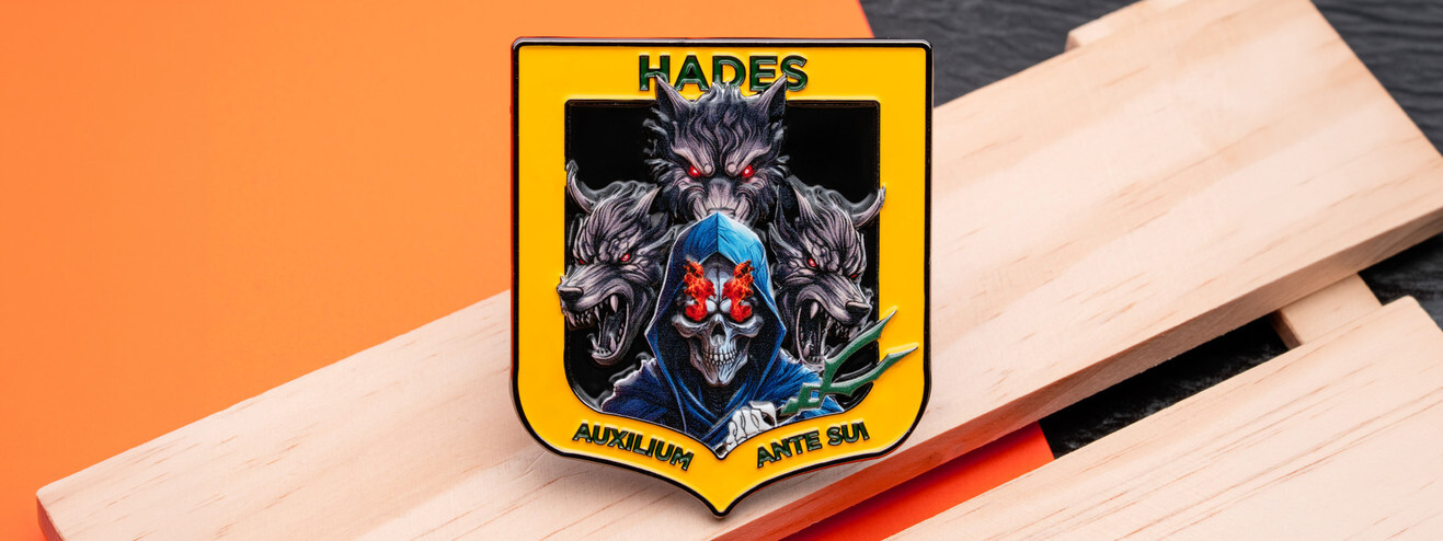 Yellow shield shaped coin printed in full color with a hooded skull and three snarling wolves, on light wood and orange paper