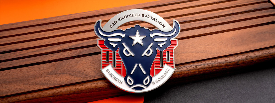 Engineer battalion coin with a longhorn and stars on a walnut board