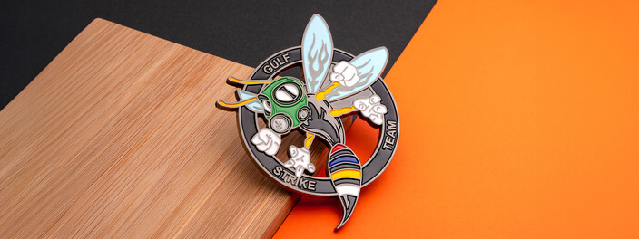 Cutout coin of a cartoon hornet in a green gas mask flexing its arms inside a dark Gulf Strike Team ring