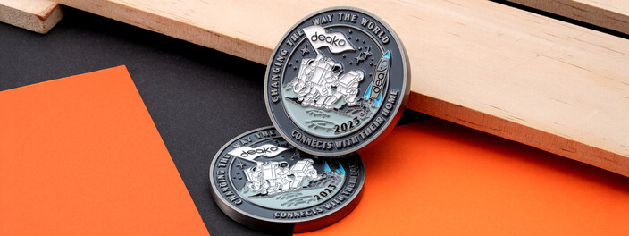 Two antique silver coins with astronauts planting a company flag on the moon beside a rocket