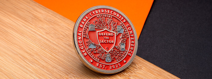 Red coin with a Defend the Sector shield over a circuit map and binary code, for a regional bank cybersecurity conference