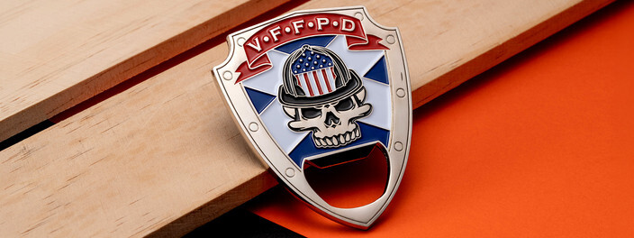 Shield shaped coin with a skull in a firefighter helmet over an American flag, on a wooden board
