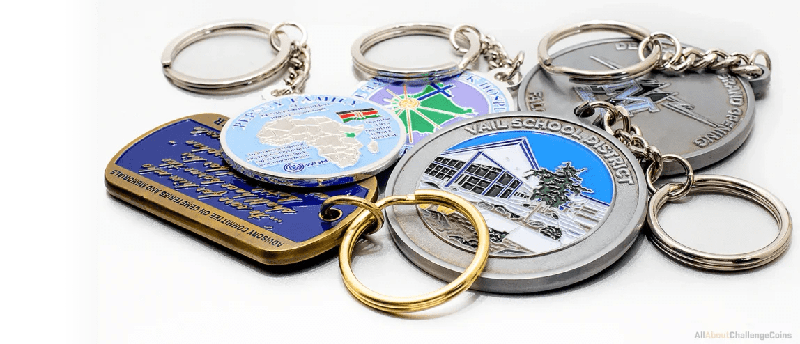 Round and rectangular enamel keychains in blue, green and antique silver with split rings and chains, on white