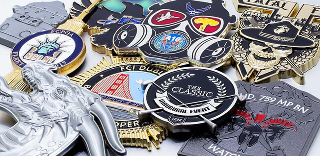 Custom-shaped challenge coins in shield, badge, star, and figure outlines