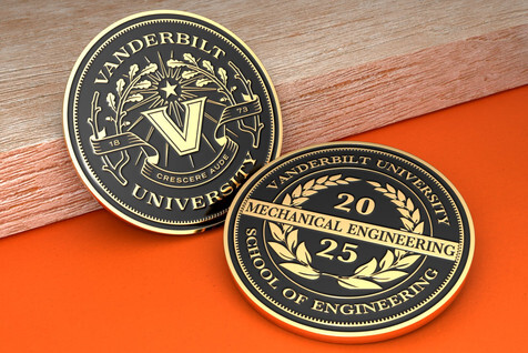 Two matching university engineering coins, one showing the front and one the back