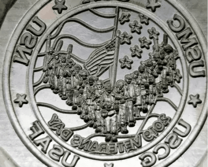 Steel coin mold with a mirrored military crest engraved into its face