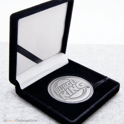 Silver challenge coin in an open black velvet presentation box