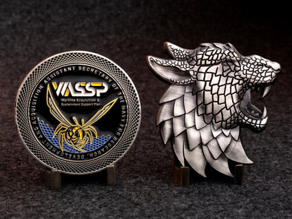 VASSP Navy challenge coin beside a silver wolf-head shaped coin on display stands