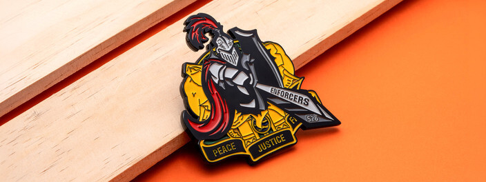 Cutout coin of an armored knight with a red plume and a sword over a yellow shield, on light wood