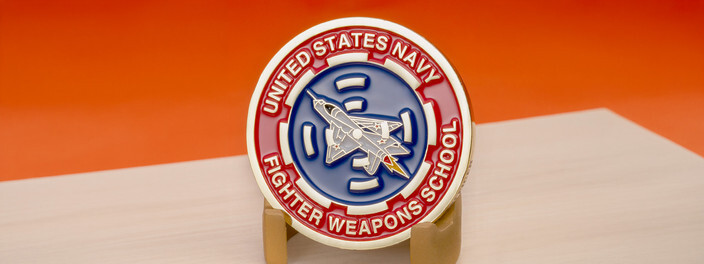 Gold coin with a red ring and a fighter jet in a blue target, for the United States Navy Fighter Weapons School