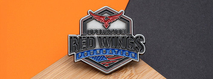 Silver hexagon foundation coin with a red eagle and an American flag, on bamboo and orange paper