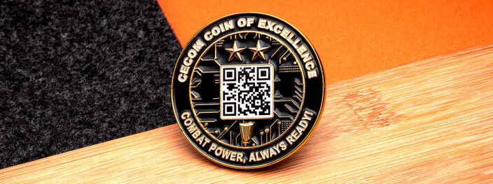 Black and gold coin of excellence with a white QR code over circuit lines and two stars