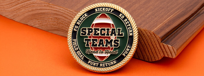 Gold rope edged football coin with Special Teams lettering over a football on green